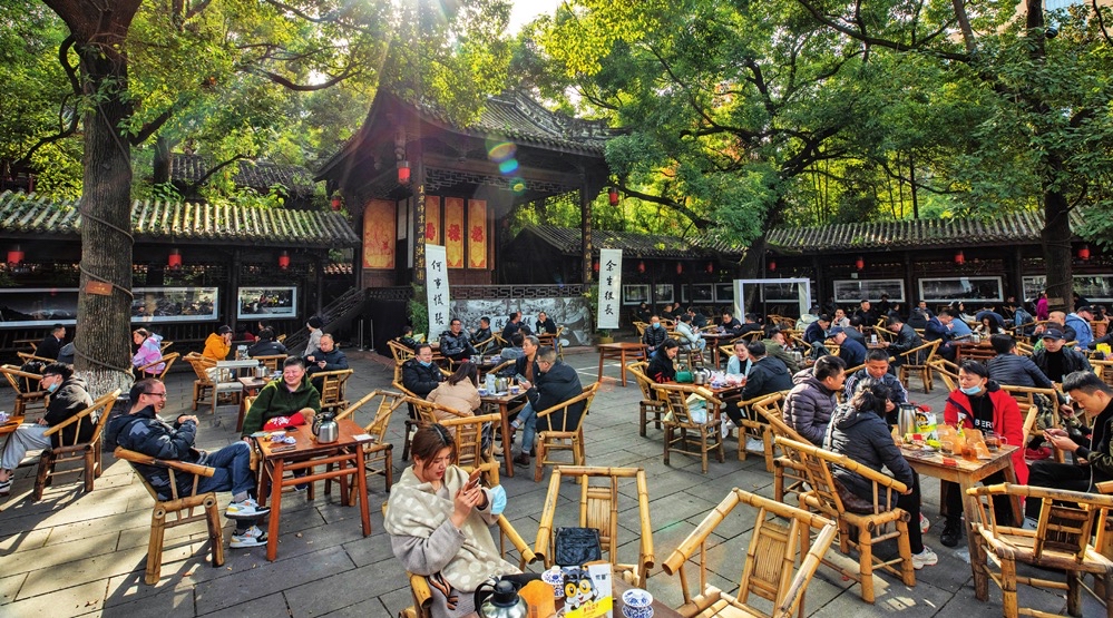 Traditional Chinese tea house courtyard with bamboo tables under ancient trees