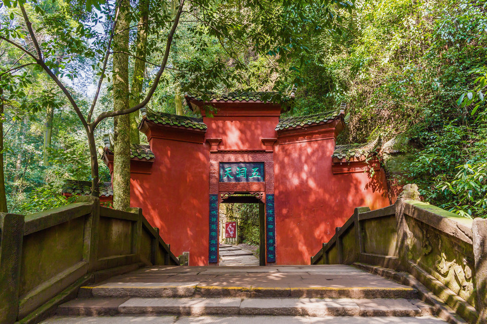 Ancient stone steps leading up Mount Qingcheng through lush green forest, the birthplace of Taoism