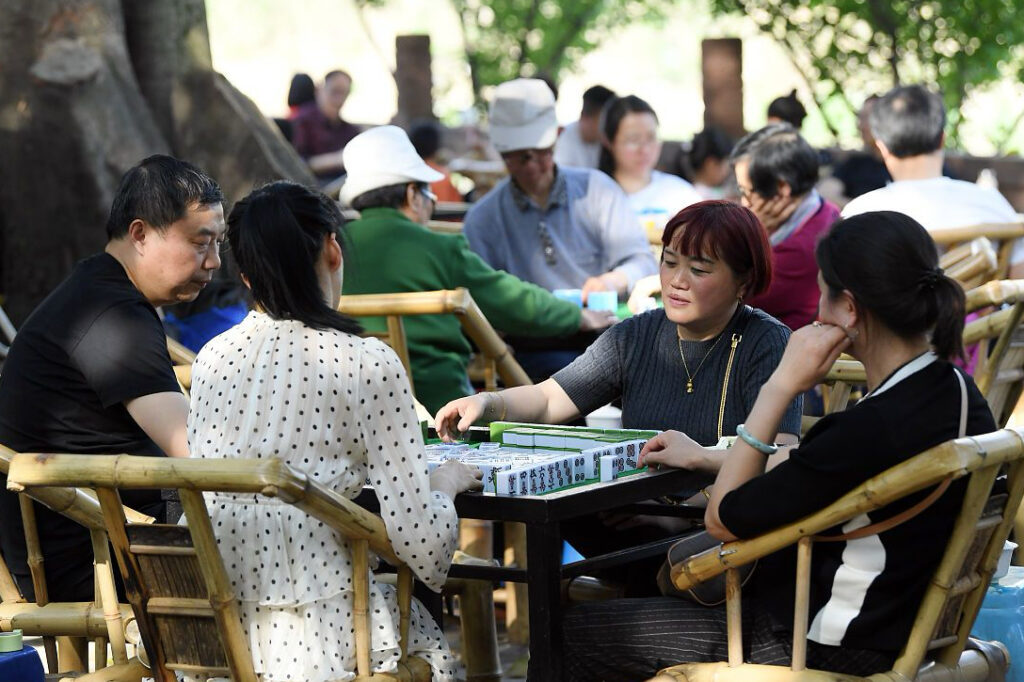 Locals playing mahjong at outdoor tables in a Chengdu park