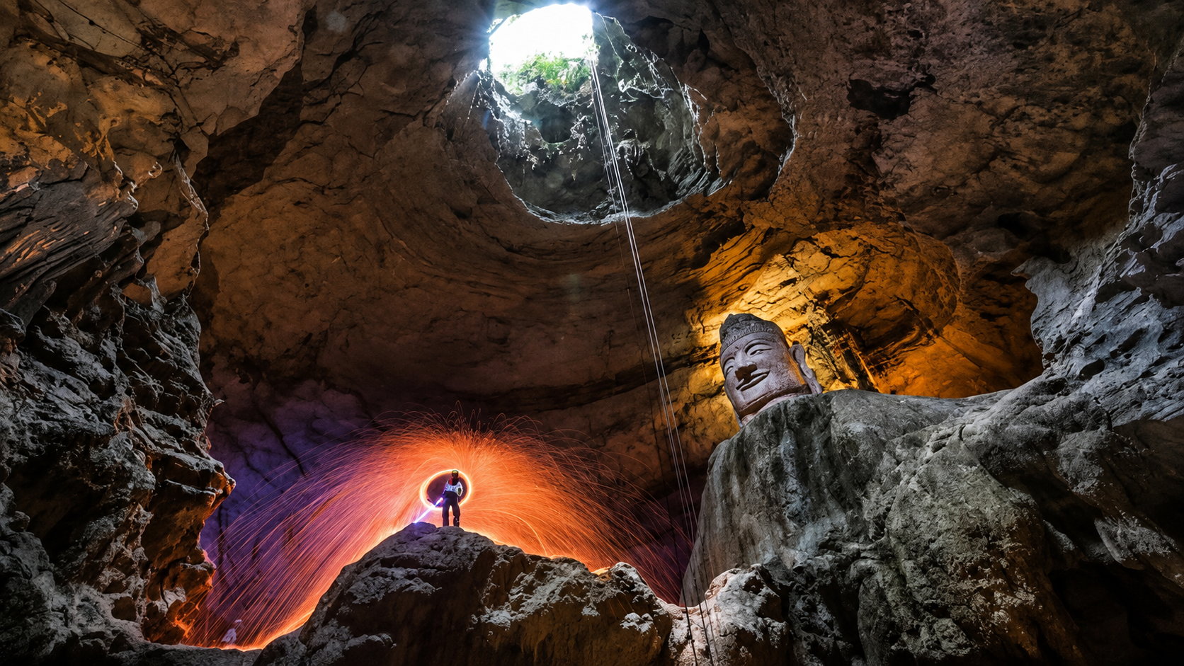 Steel wool light painting inside Tianyan Cave with the giant stone Buddha and natural skylight, a unique photo opportunity near Chongqing